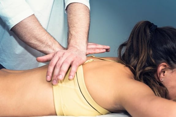 Chiropractor Adjusting Patient with Back Pain