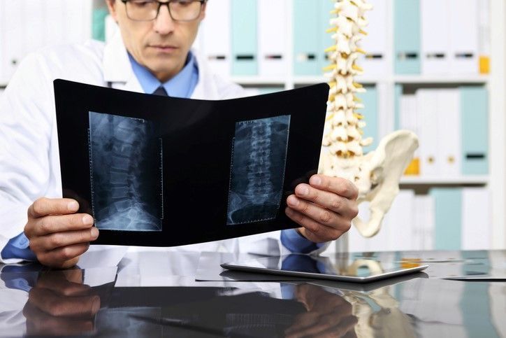 Chiropractor_looking_at_herniated_disc_x-ray