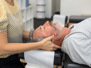A man getting a spinal manipulation through a chiropractic adjustment