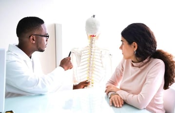 chiropractor explains a condition to his patient