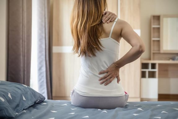 woman with back pain in need of chiropractic care from arrowhead clinic.
